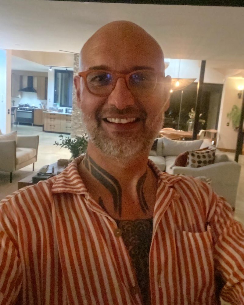 Dewan in a striped shirt, smiling