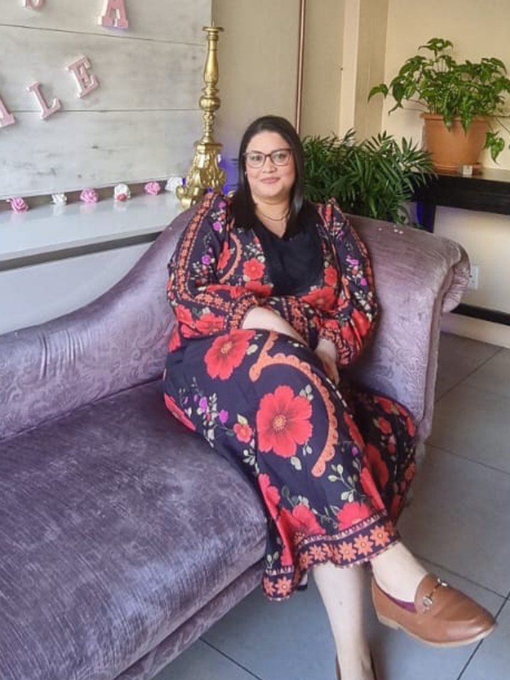 Ilaam on a velvet chaise in a floral dress
